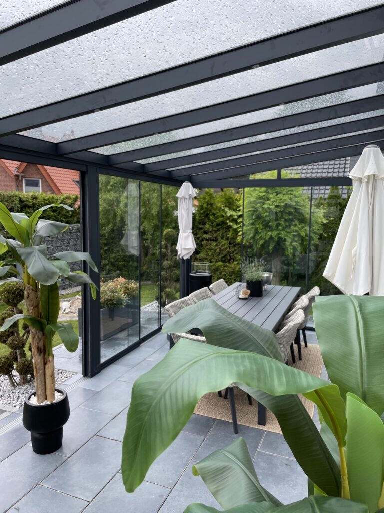 Alu-Terrassenüberdachung mit Glasschiebewänden in Delbrück. Maße: 850x300 cm