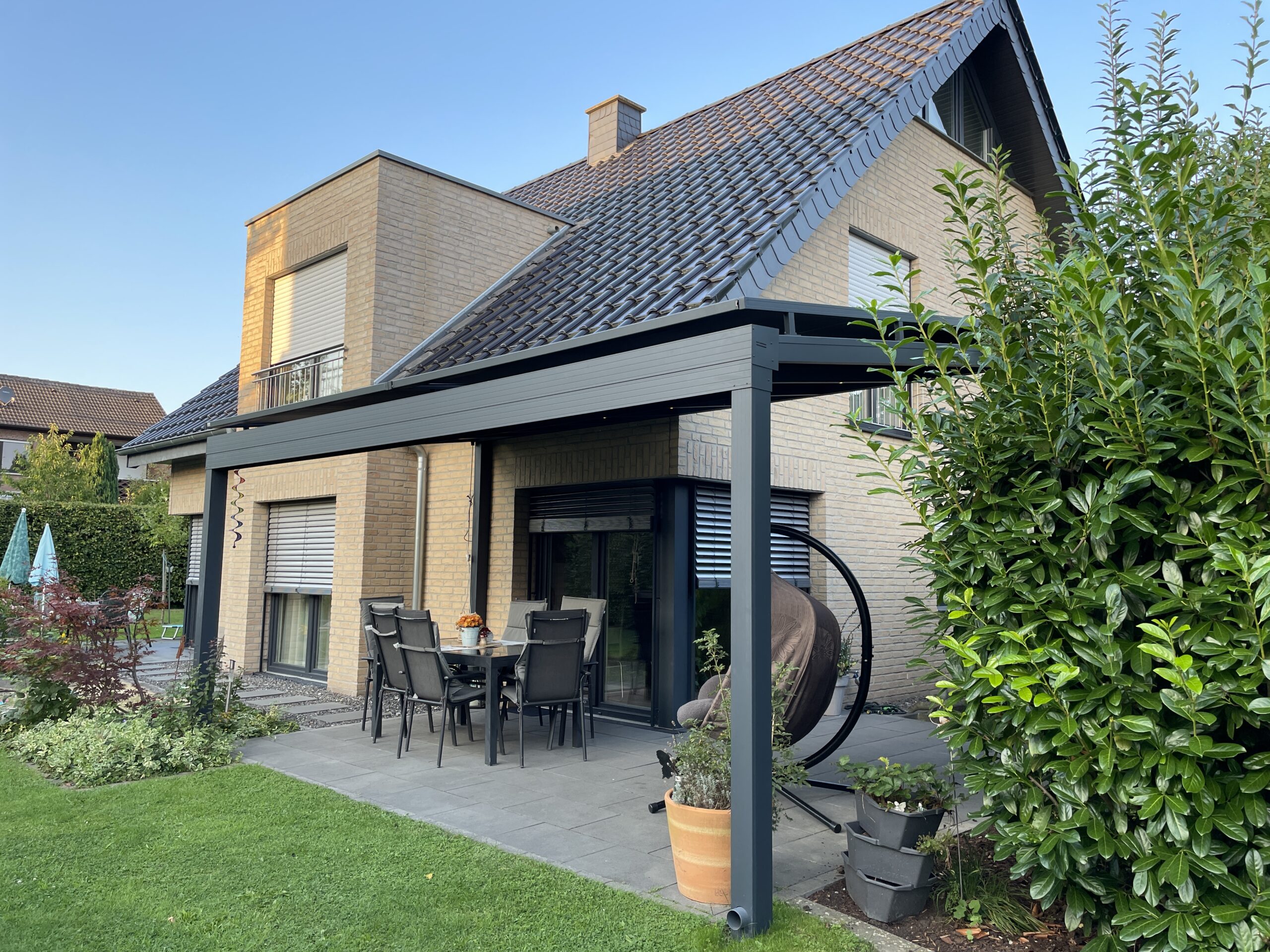 Terrassenüberdachung aus Aluminium mit klarem Dach an Einfamilienhaus
