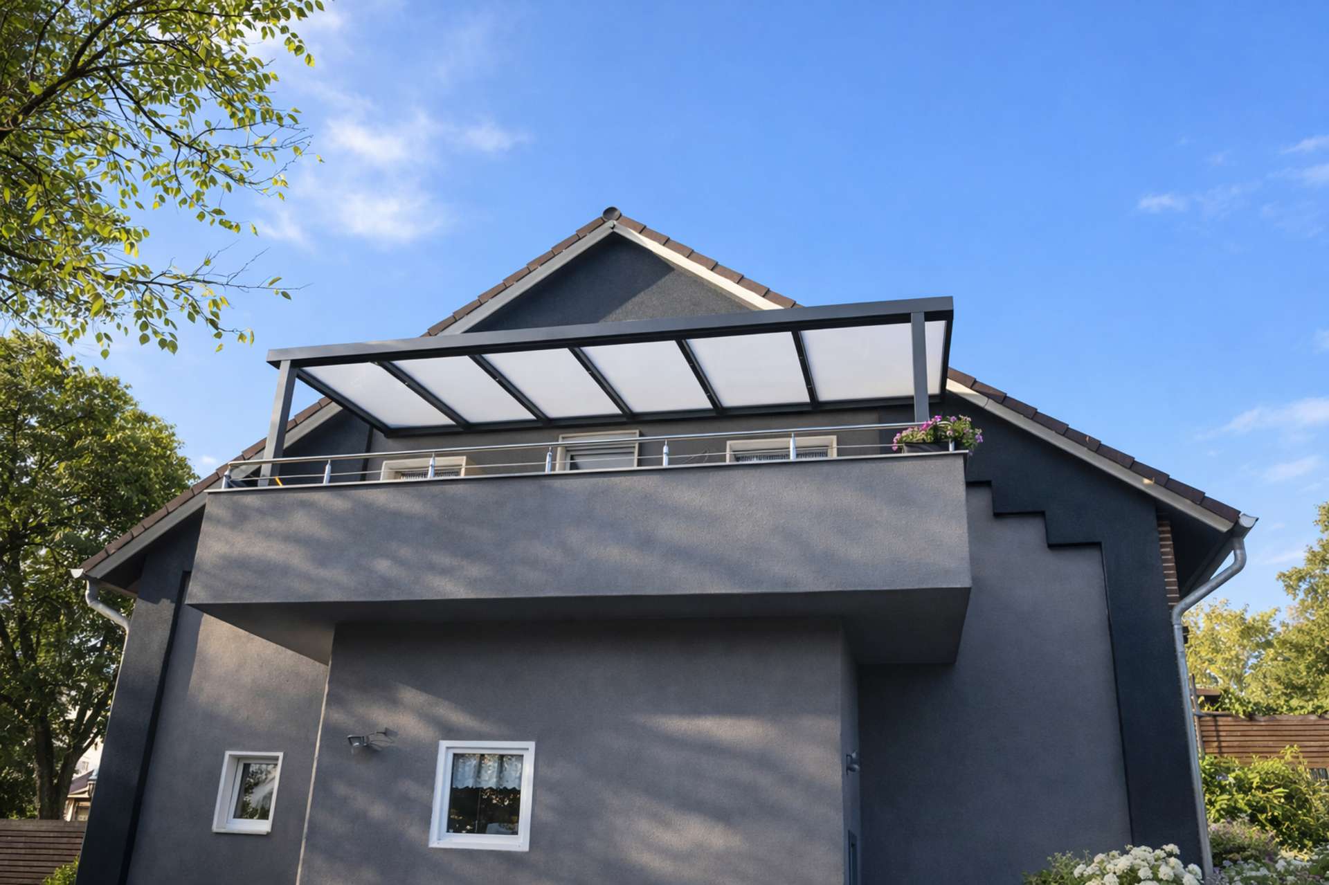 Balkonüberdachung aus Aluminium mit Milchglasdach an modernem Einfamilienhaus