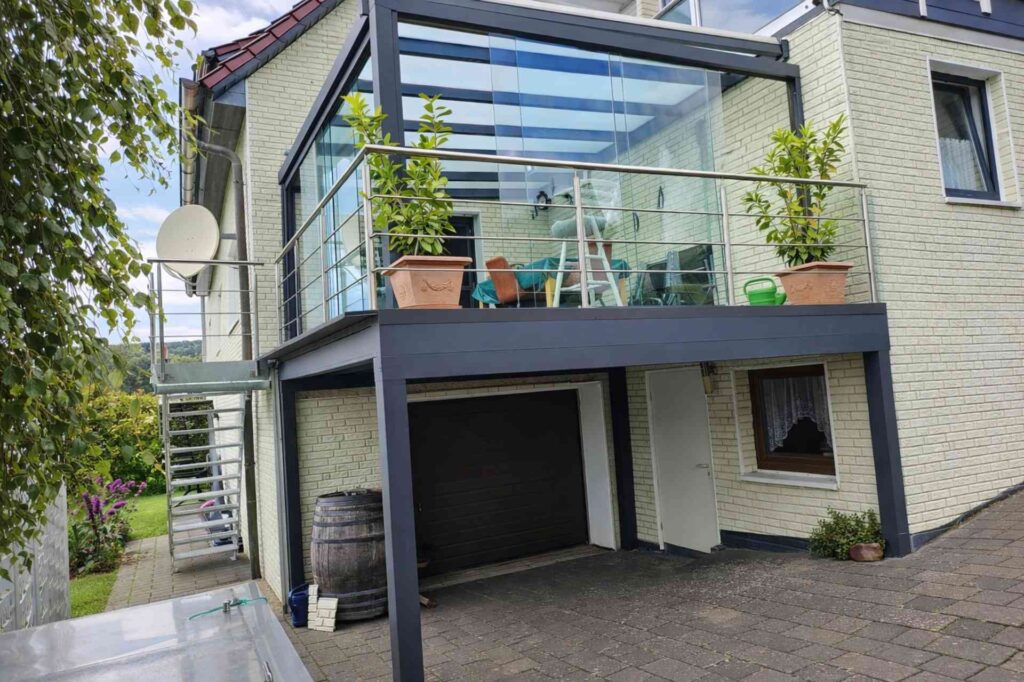 Balkon mit Aluminiumüberdachung und Glaswänden auf Garage