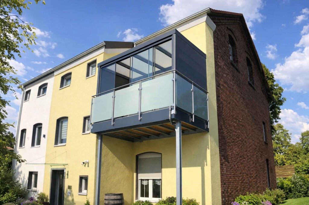 Balkon mit Aluminiumüberdachung und seitlicher Verglasung an modernem Haus