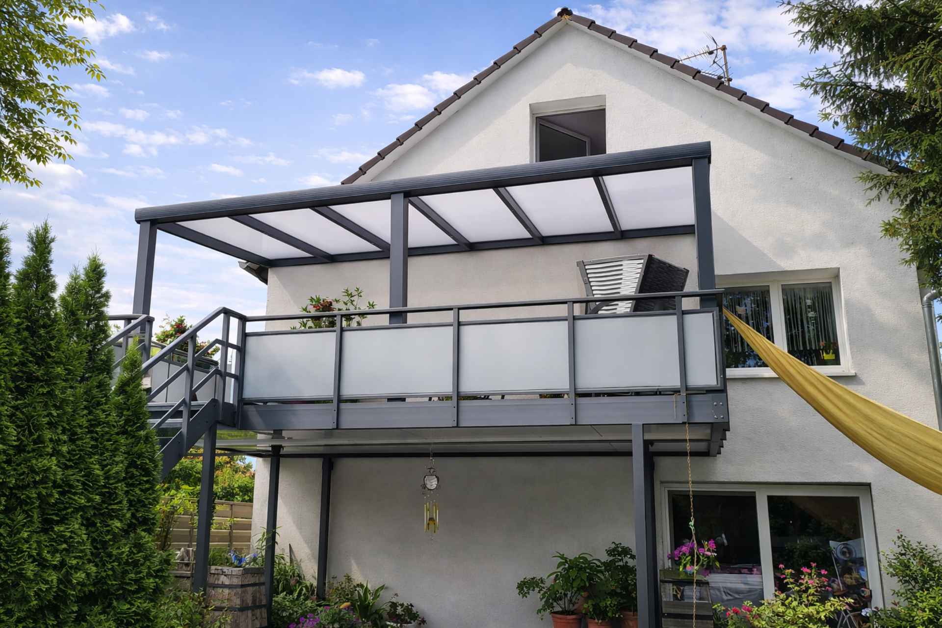 Balkon mit Aluminiumüberdachung und Milchglasgeländer an Einfamilienhaus