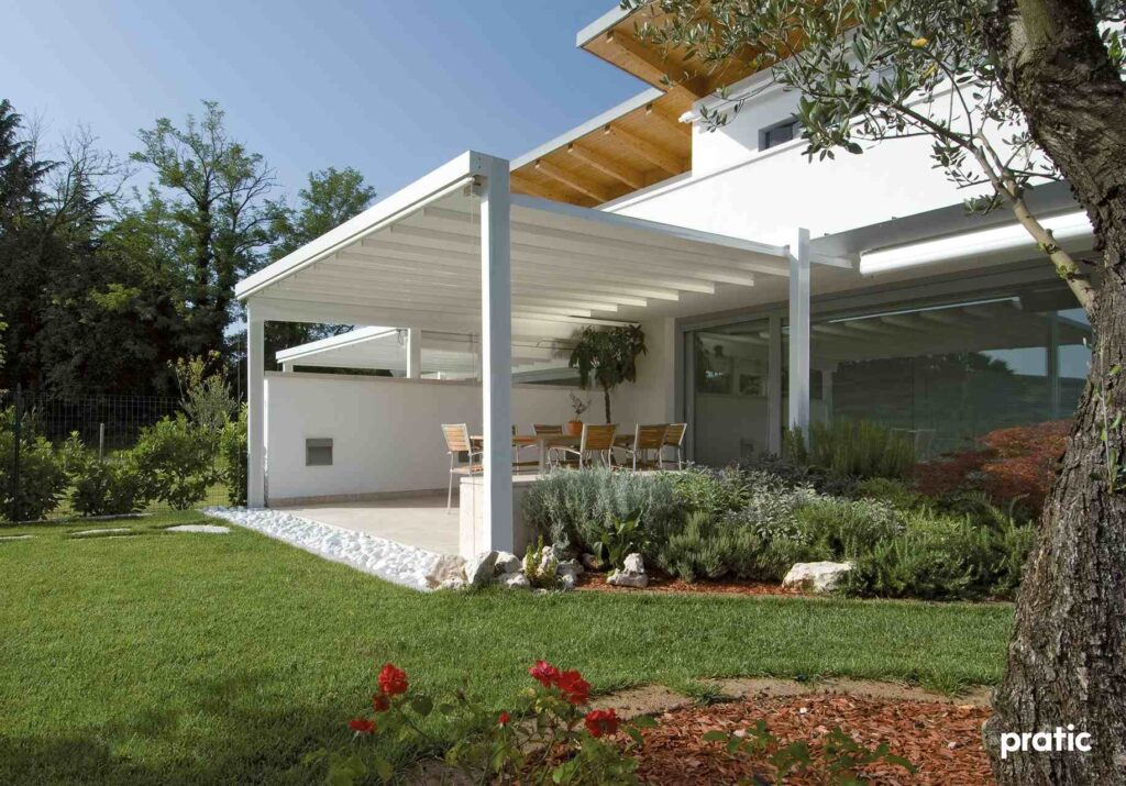 Weiße Terrassenüberdachung aus Aluminium mit Lamellendach im modernen Garten