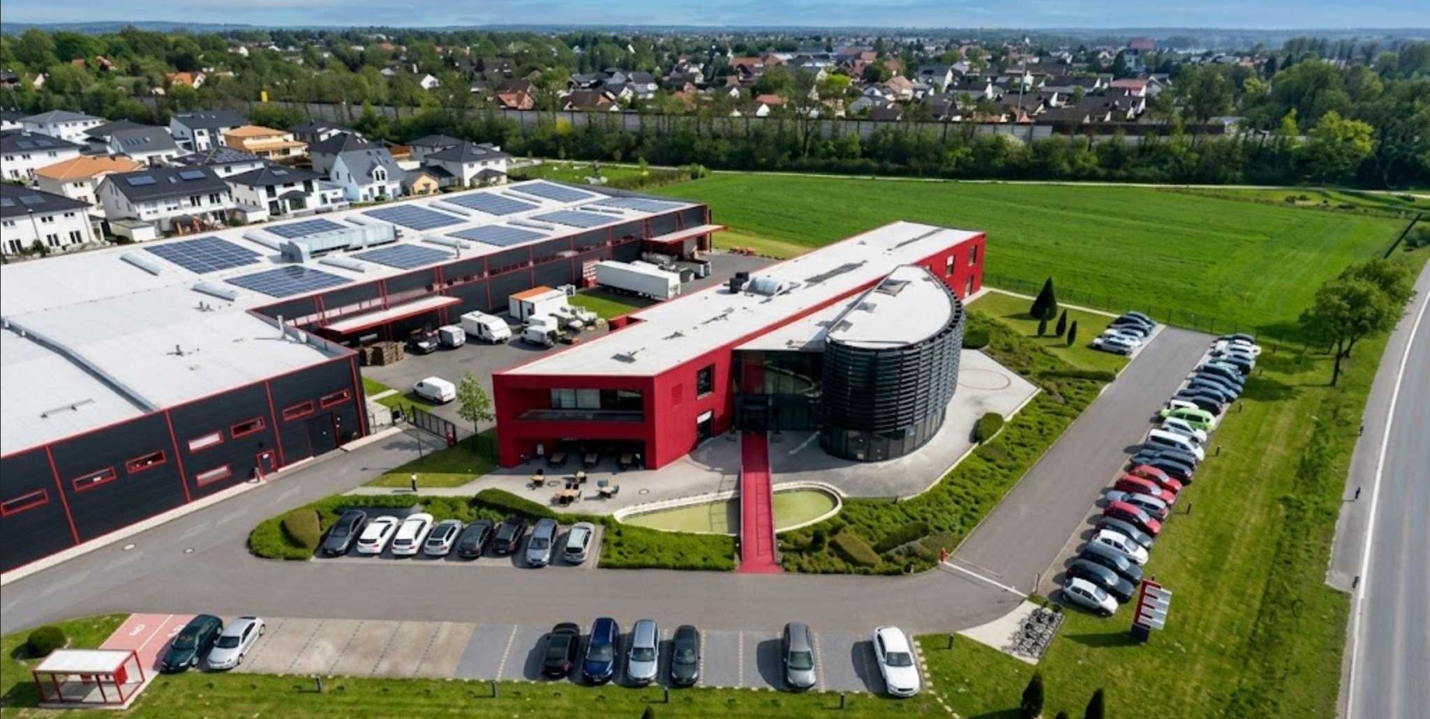 Luftaufnahme des PREMLUX Firmengeländes mit Showroom, Produktionshalle und Parkplatz