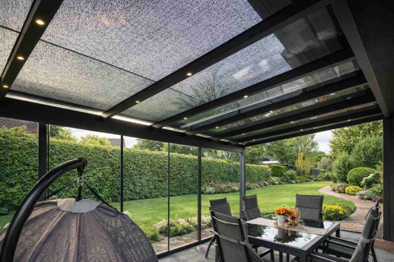 Terrassenüberdachung mit Glasdach und Seitenelementen im Garten