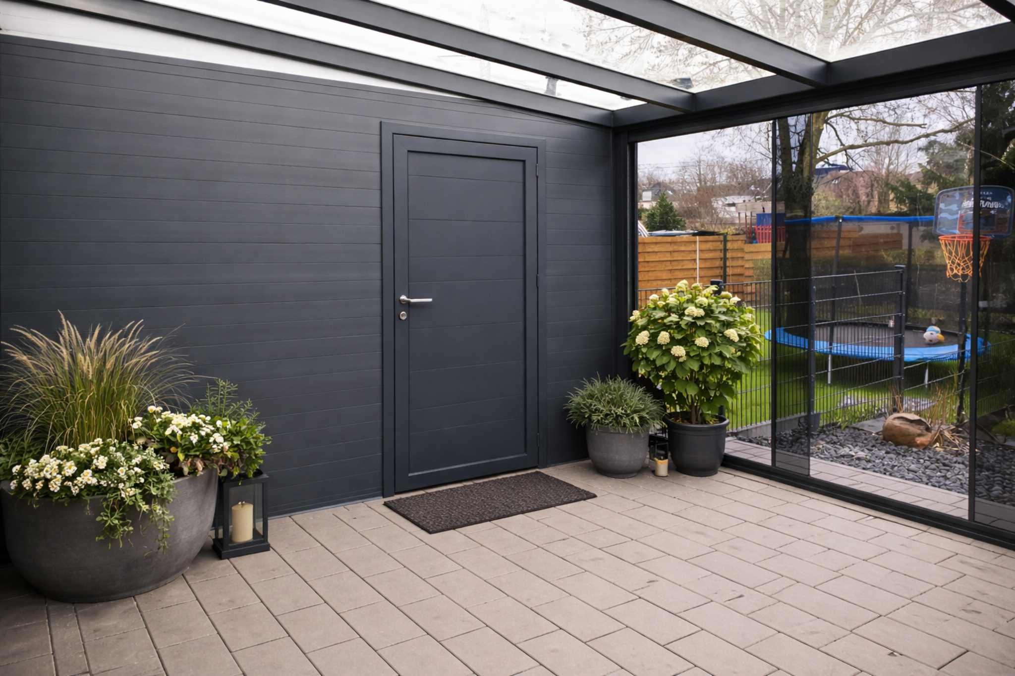 Überdachte Terrasse mit Aluminiumkonstruktion und integrierter Tür