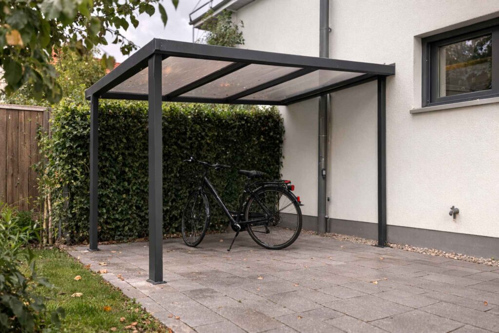 Fahrradunterstand mit Aluminium-Überdachung und transparentem Dach an Hauswand