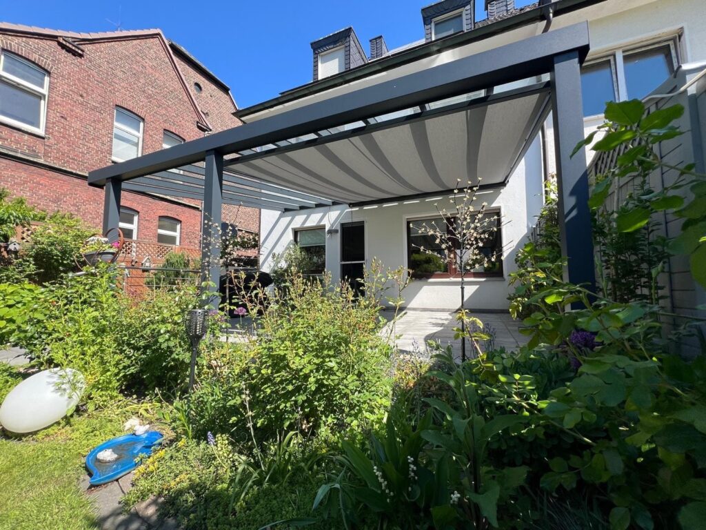 Terrassenüberdachung mit grauer Unterdachmarkise im Garten