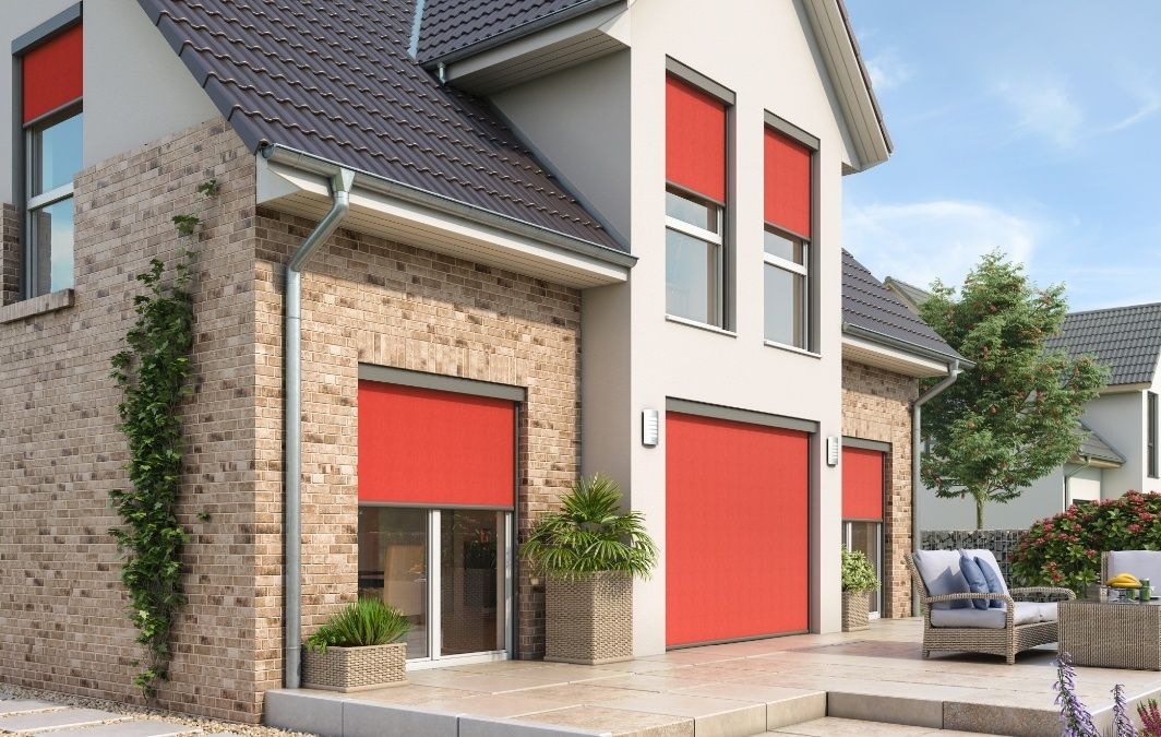 Einfamilienhaus mit roten Außenrollos an Fenstern und Terrassentür
