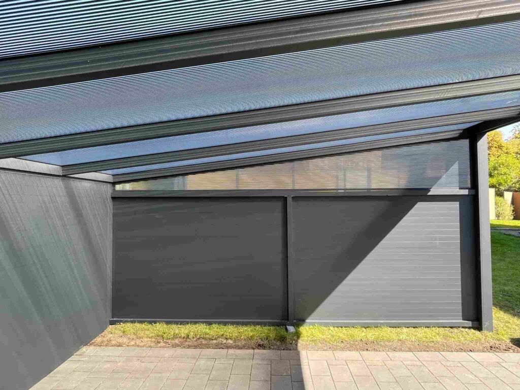 Innenansicht einer modernen Terrassenüberdachung mit geneigtem Glasdach und geschlossenen Seitenwänden