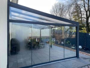 Komplett verglaste Terrassenüberdachung aus Aluminium mit Schiebetüren