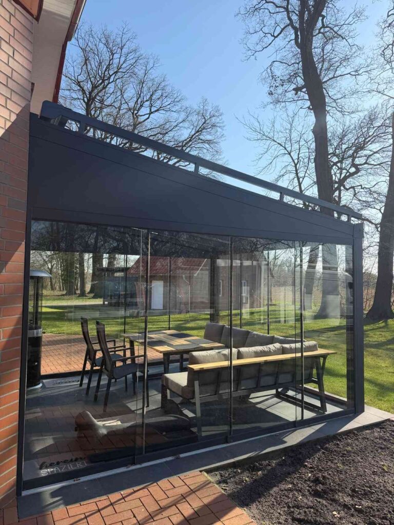 Vollverglaste Terrassenüberdachung aus Aluminium mit moderner Sitzgruppe