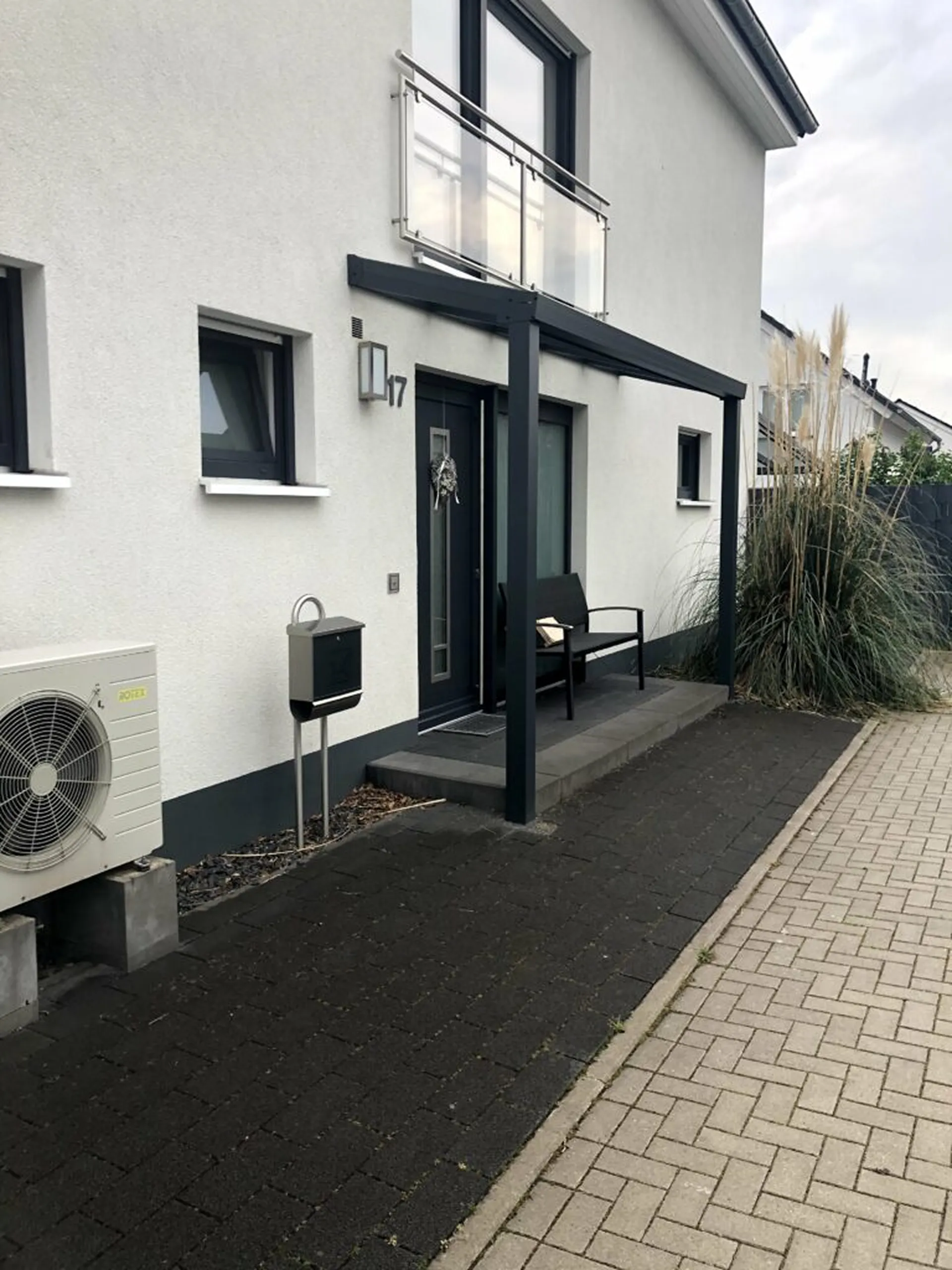 Eingangsüberdachung aus Aluminium mit modernem Design an Einfamilienhaus