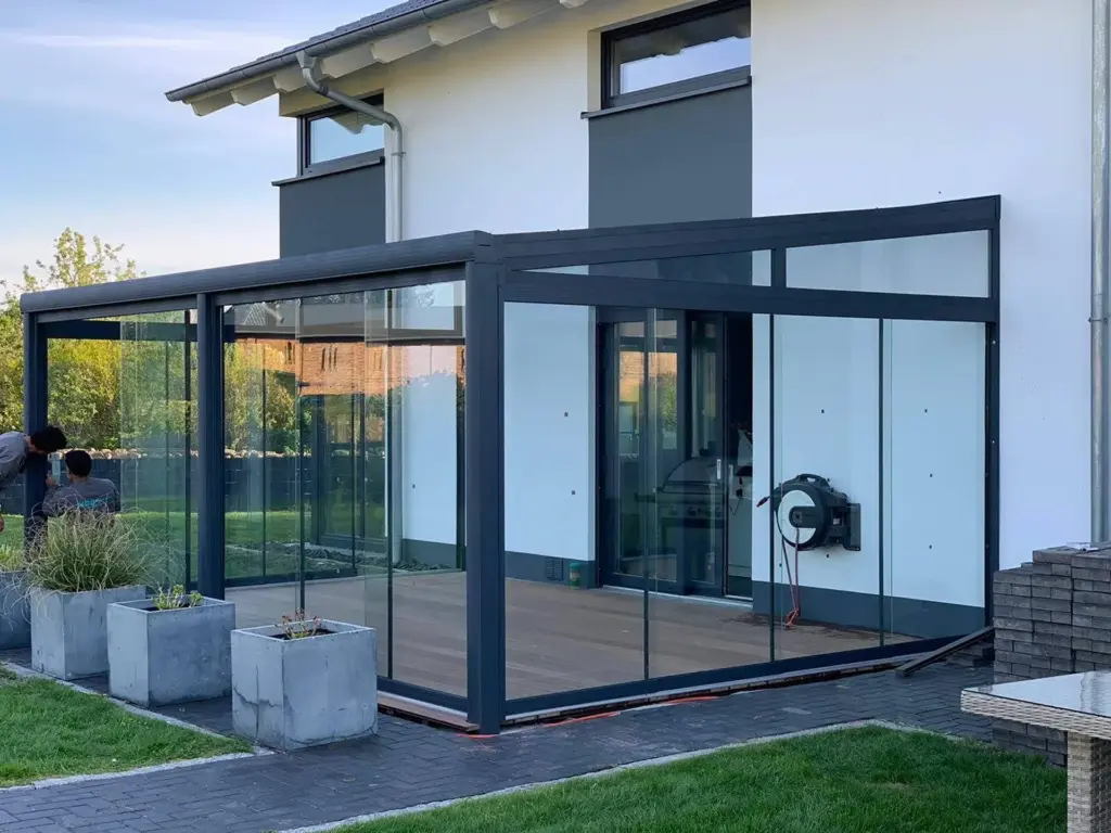 Moderner Kaltwintergarten mit Glas-Schiebeanlage und Aluminiumrahmen am Einfamilienhaus