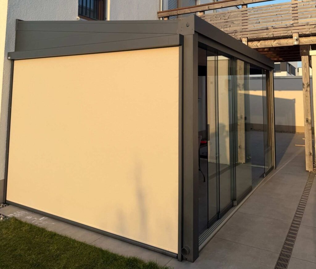 Terrassenüberdachung mit Glasschiebetüren und seitlichem Sonnenschutz-Screen in modernem Design