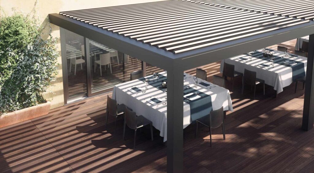 Pergola mit geschlossenem Lamellendach über einem gedeckten Outdoor-Esstisch