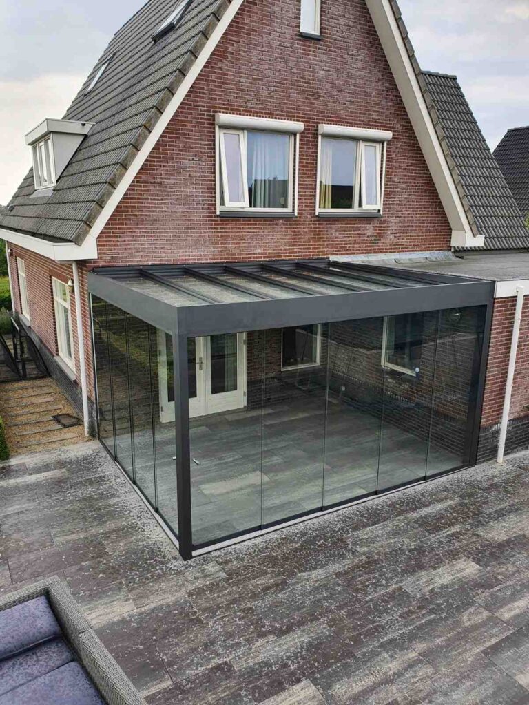 Terrassenüberdachung mit Glaswänden an Backsteinhaus für ganzjährige Nutzung