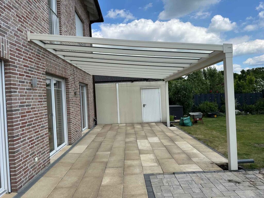 Terrassenüberdachung aus Aluminium in Weiß mit lichtdurchlässigem Dach an einem Einfamilienhaus