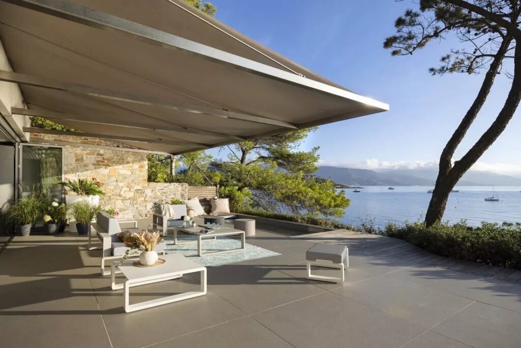 Terrassenüberdachung mit ausfahrbarer Markise auf Terrasse mit Meerblick
