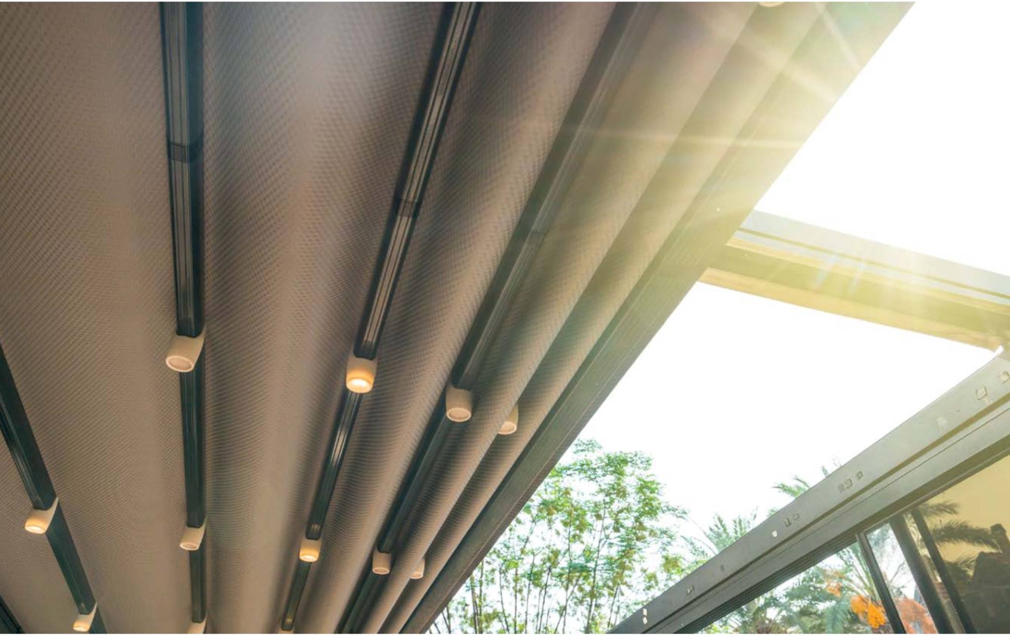Unterseite einer Terrassenüberdachung mit integriertem Sonnenschutz und Beleuchtung