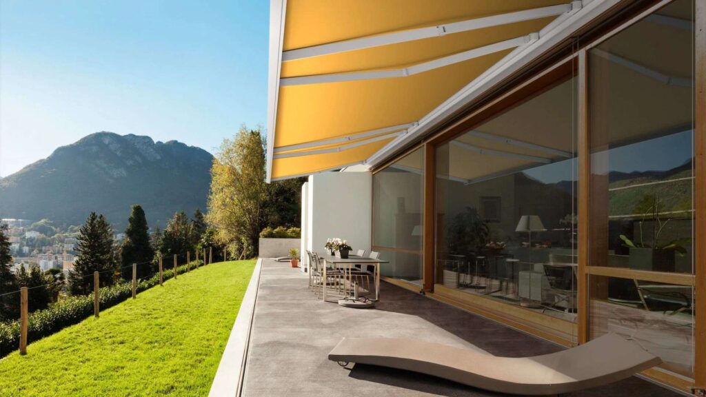 Terrasse mit ausfahrbarer Markise und Blick auf Berglandschaft