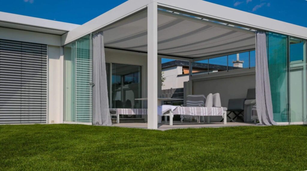 Moderne Terrassenüberdachung mit Stoffdach und seitlichen Vorhängen am Einfamilienhaus