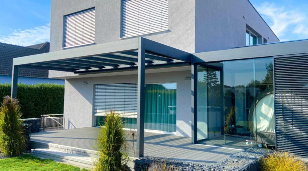 Moderne Terrassenüberdachung aus Aluminium mit Lamellendach am Einfamilienhaus