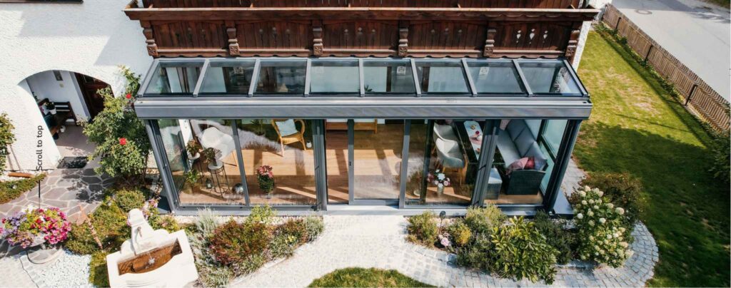 Wintergarten Terrassenüberdachung mit Glasdach und Schiebetüren am Einfamilienhaus