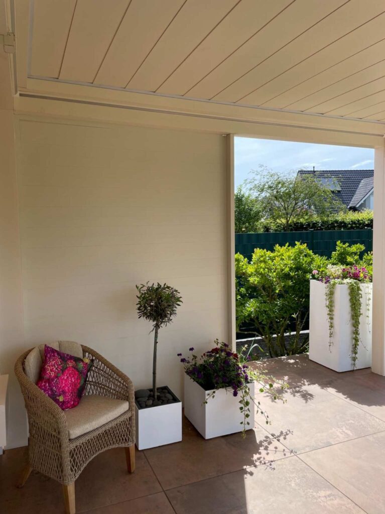 Gemütliche Sitzecke unter einer Terrassenüberdachung mit geschlossenem Dach