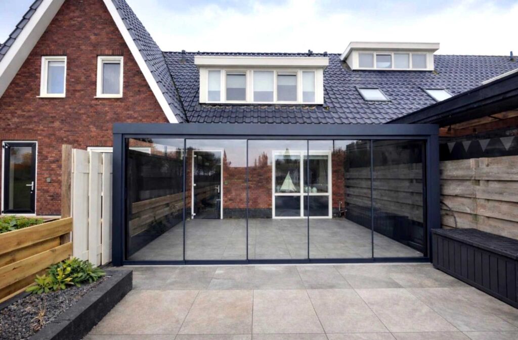 Aluminium Terrassenüberdachung Mit Glasschiebetür an einer Hauswand