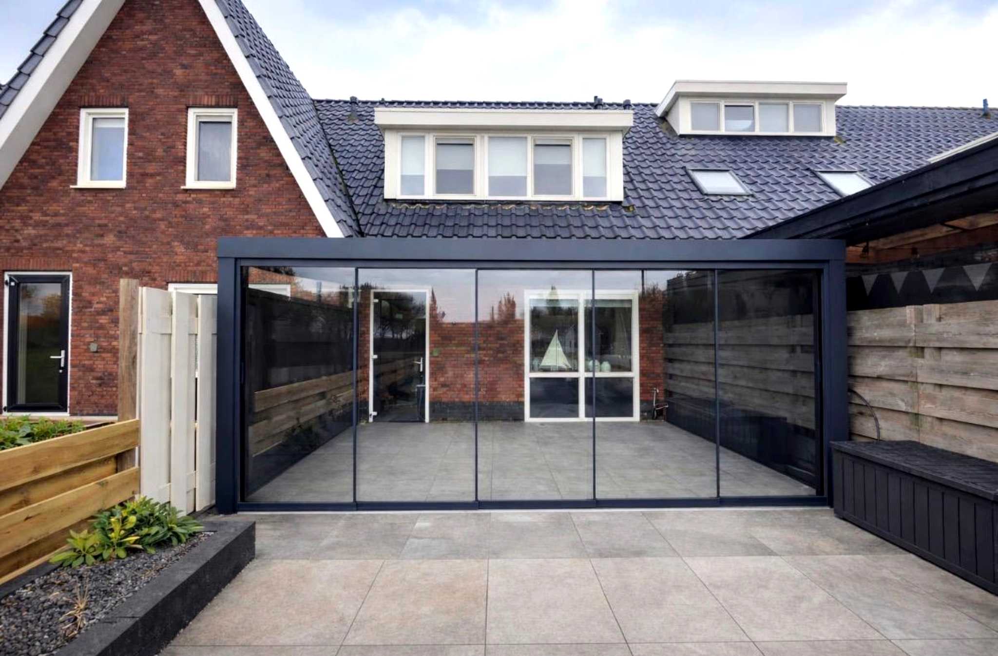 Aluminium Terrassenüberdachung Mit Glasschiebetür an einer Hauswand