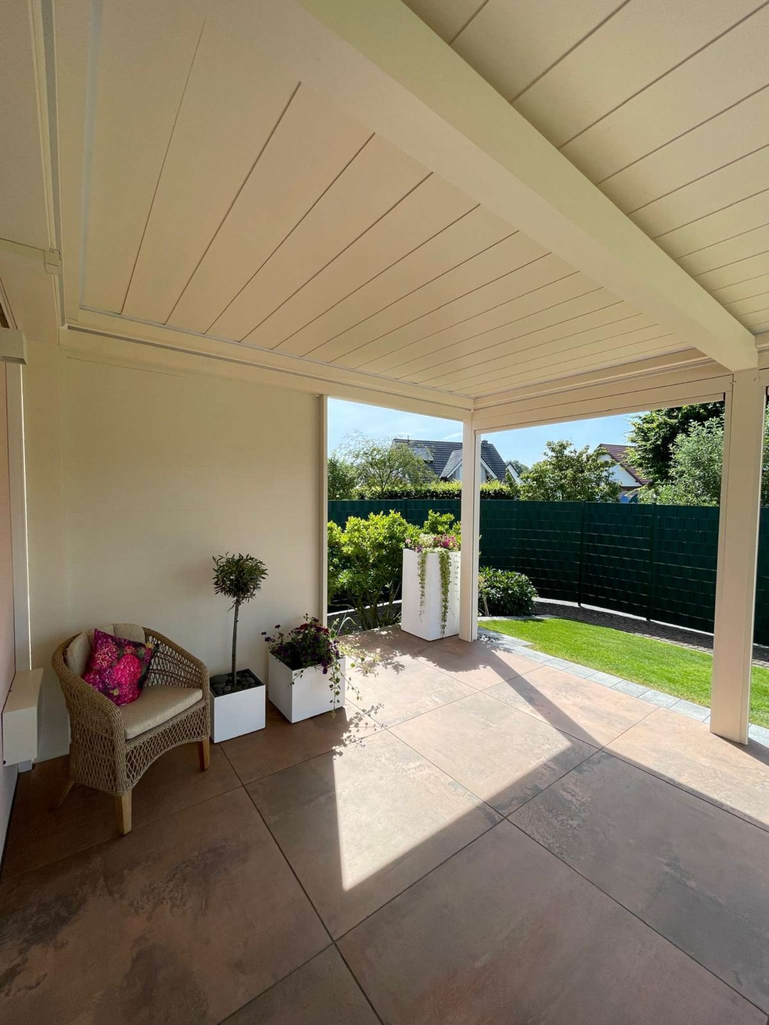 Helle Terrassenüberdachung mit geschlossenem Dach und gemütlicher Sitzecke