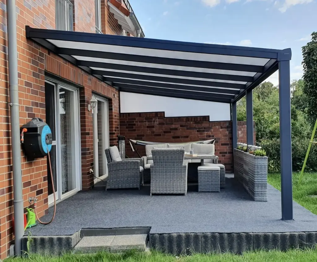 Terrassenüberdachung aus Aluminium mit Milchglasdach und Lounge-Möbeln