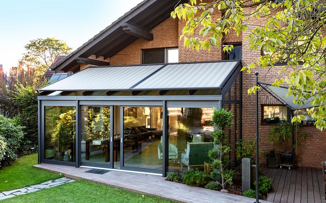 Wintergarten mit Glasdach und Aufdachmarkise am Einfamilienhaus