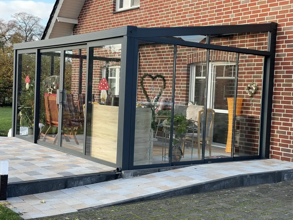 Kaltwintergarten mit Glasschiebeanlage an rotem Backsteinhaus